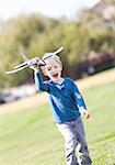 excited little boy running with a toy plane