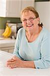 Portrait of a Beautiful Smiling Senior Adult Woman in Kitchen.