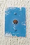 circular antique elevator call button on an old painted wall