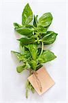 Fresh green basil leaves on a white cloth with a label.