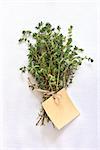 Fresh green thyme leaves on a white cloth with a label.