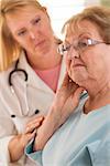 Melancholy Senior Adult Woman Being Consoled by Female Doctor or Nurse.