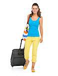 Smiling young tourist woman with wheel bag going straight