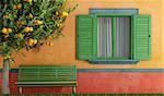 Colorful  old house with  wooden window and green bench - rendering