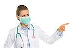 Medical doctor woman in mask pointing on copy space