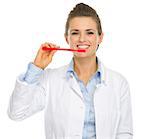 Smiling dental doctor woman showing how to clean teeth