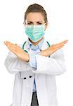 Concerned medical doctor woman in mask showing stop gesture