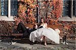 Portrait of Groom Lying in Bride's Lap on Bench in Autumn, Toronto, Ontario, Canada