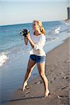 Young Woman Taking Pictures at Beach with Camera, Palm Beach Gardens, Palm Beach, Florida, USA