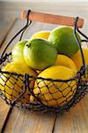 Lemons and Limes in Wire Basket, Studio Shot