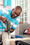 African man using drill in a workshop