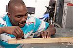 African man making measurements in a workshop