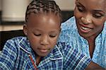 Closeup of young African girl in school uniform sitting with her mother