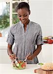 Young African mother making food in the kitchen