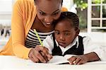 Young African mother helping her daughter with her homework