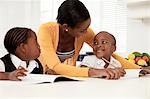 Young African mother helping her children with their homework