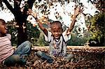 Two young African siblings okay together in a park