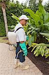 Pest control technician with portable spray rig using  spray nozzle and hose