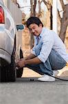 Chinese man putting air in his car tires