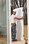 Hispanic carpenter about to make new door installation on house