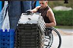 Loading dock worker with spinal cord injury in a wheelchair moving stacked inventory trays