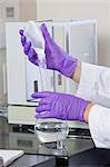 Laboratory scientist adding a premeasured amount of solid reagent to a water sample in a flask