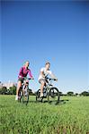 Couple riding mountain bikes in a park