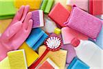 still life of cleaning products including sponges, bottles, rubber gloves, and scrub brushes