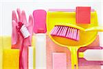 still life of cleaning products including sponges, plastic bottle, rubber gloves, dustpan, and hand broom