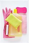 still life of cleaning products including sponges, bottle of cleaner, and rubber glove