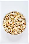 Popped popcorn in bowl on white background