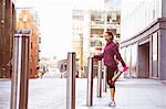 Woman stretching on city street