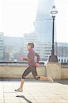 Woman running on urban bridge