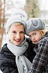 Mother carrying daughter in snow