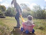 Mother pulling toddler girl in wagon