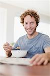 Man reading newspaper at breakfast