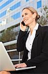 Businesswoman using laptop outdoors