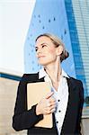 Businesswoman carrying folder outdoors