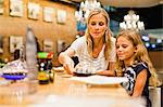 Mother and daughter eating at restaurant