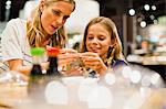 Mother and daughter using chopsticks