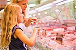 Mother and daughter at butcher counter