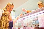 Mother and daughter at butcher counter