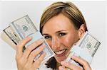 Smiling woman holding wads of cash