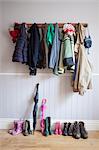 Coats on coat rack with boots