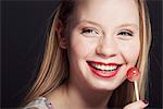 Smiling woman eating lollipop