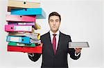 Businessman with stacks of folders and tablet computer