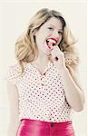 Smiling woman eating lollipop