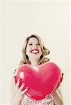 Woman holding heart shaped balloon