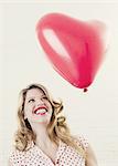 Smiling woman with heart shaped balloon