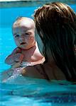 Mother holding baby in swimming pool